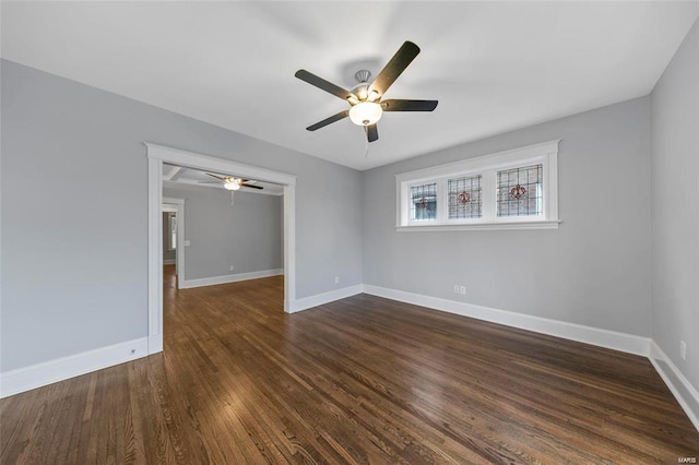 unfurnished room featuring a ceiling fan, baseboards, and dark wood-style floors