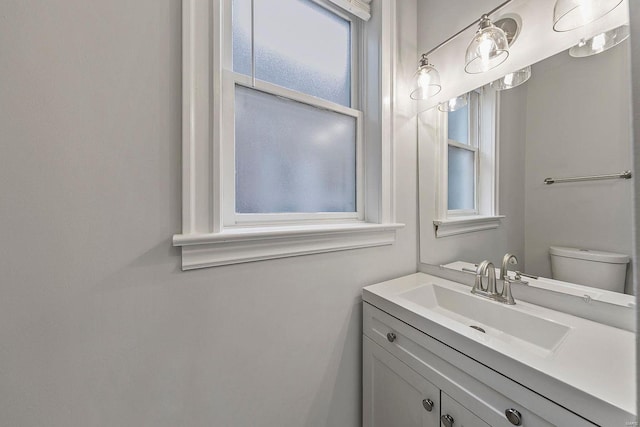 half bathroom featuring vanity and toilet