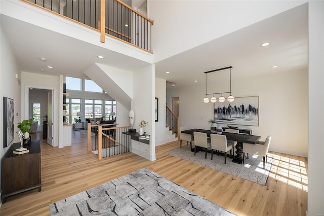 entrance foyer with wood finished floors, stairway, a high ceiling, recessed lighting, and baseboards