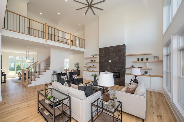 living room with a high ceiling, stairs, light wood-style floors, recessed lighting, and a ceiling fan
