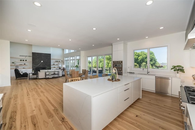 kitchen featuring appliances with stainless steel finishes, modern cabinets, a sink, white cabinets, and recessed lighting