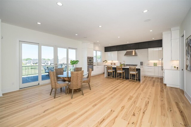 dining space featuring light wood finished floors and recessed lighting