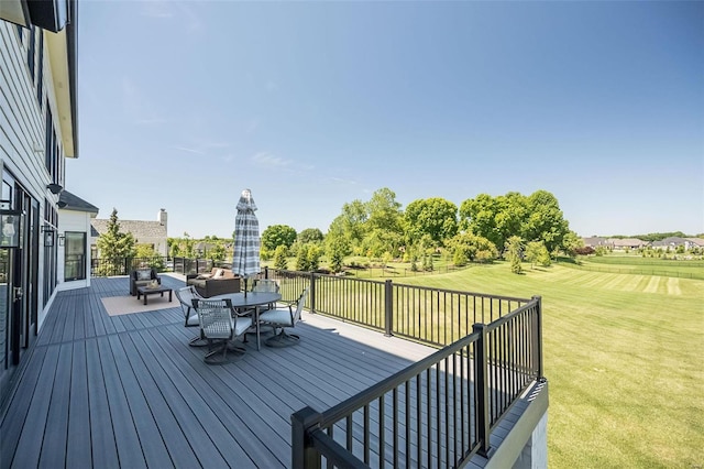 wooden deck with a lawn and outdoor dining space