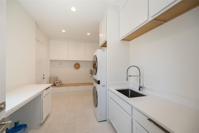 clothes washing area with stacked washer / drying machine, cabinet space, recessed lighting, and light tile patterned floors