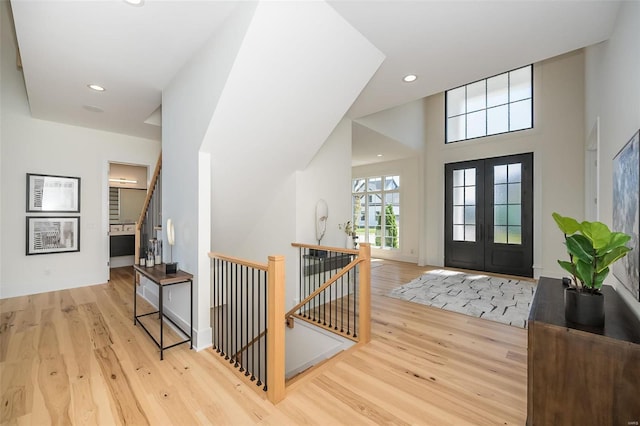foyer with wood finished floors, recessed lighting, and french doors