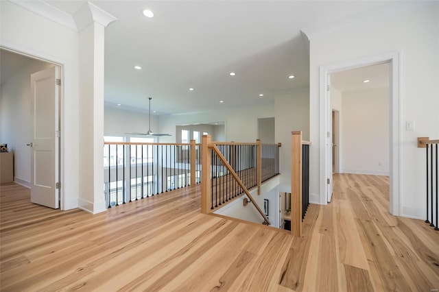 hall with an upstairs landing, wood finished floors, recessed lighting, and baseboards