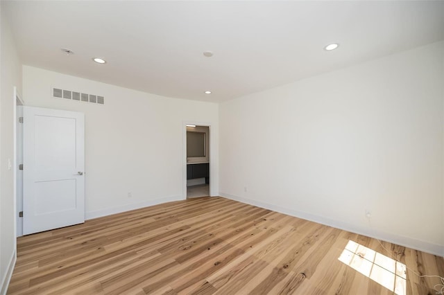 empty room featuring light wood-style floors, recessed lighting, and baseboards