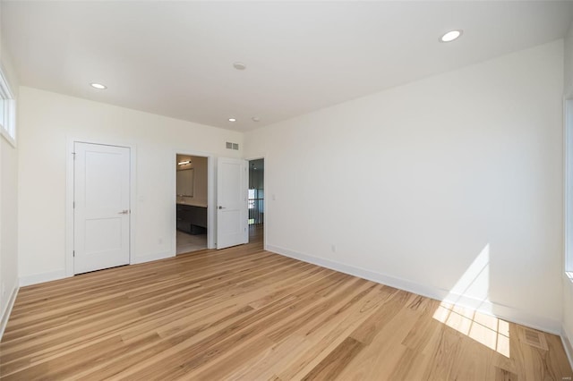 unfurnished bedroom with light wood-style floors, baseboards, recessed lighting, and ensuite bathroom