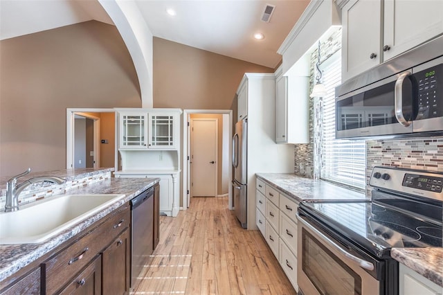 kitchen featuring appliances with stainless steel finishes, a sink, white cabinetry, backsplash, and recessed lighting