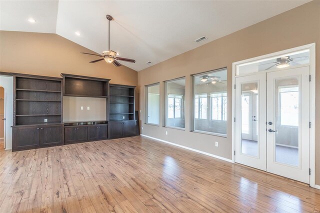unfurnished living room featuring a ceiling fan, vaulted ceiling, light wood-style floors, and french doors