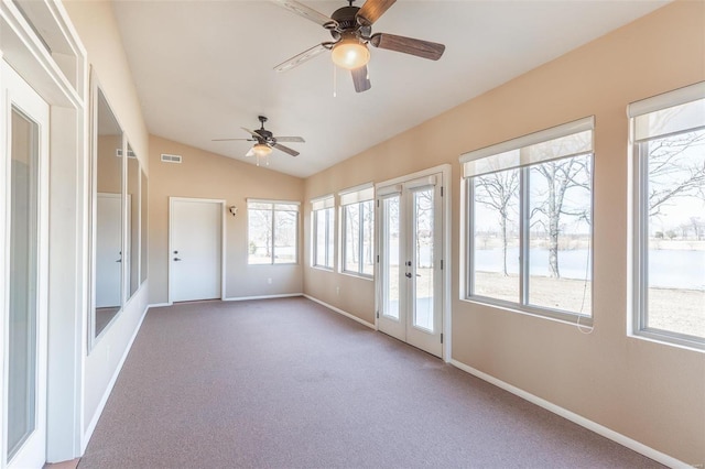 unfurnished sunroom with lofted ceiling, a water view, and french doors