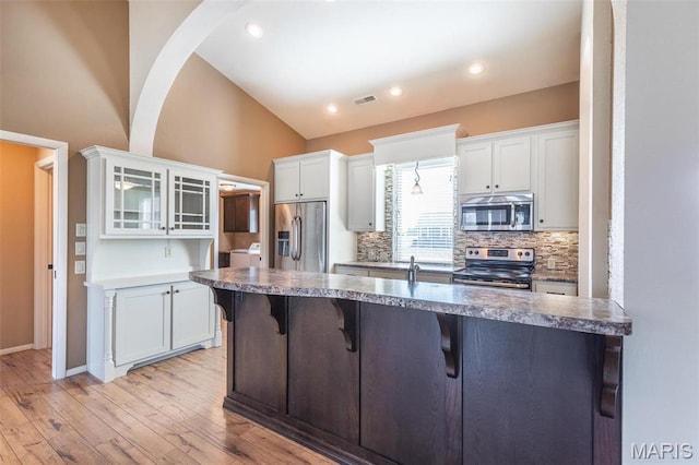 232 Confederate Ridge Rd, Doniphan, MO 63935 - kitchen featuring stainless steel appliances, lofted ceiling, a breakfast bar, white cabinetry, and glass insert cabinets