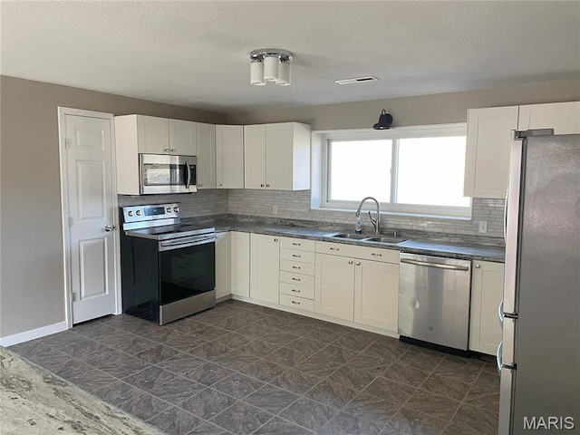1770 Pigg Hollow Rd, Owensville, MO 65066 - kitchen featuring stainless steel appliances, a sink, backsplash, white cabinetry, and a textured ceiling