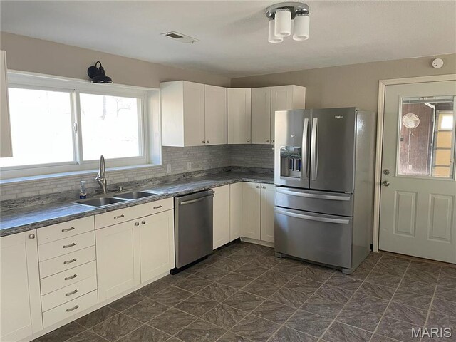 1770 Pigg Hollow Rd, Owensville, MO 65066 - kitchen featuring appliances with stainless steel finishes, a sink, decorative backsplash, and white cabinetry