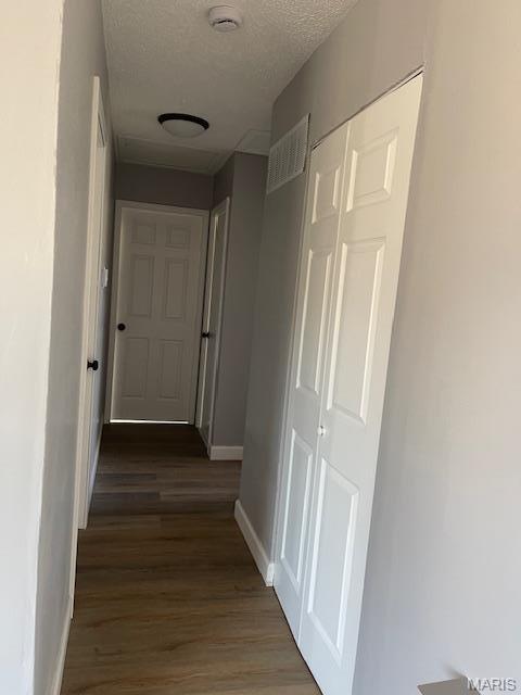 1339 Cabrillo Dr, Saint Louis, MO 63138 - corridor featuring a textured ceiling, wood finished floors, and baseboards