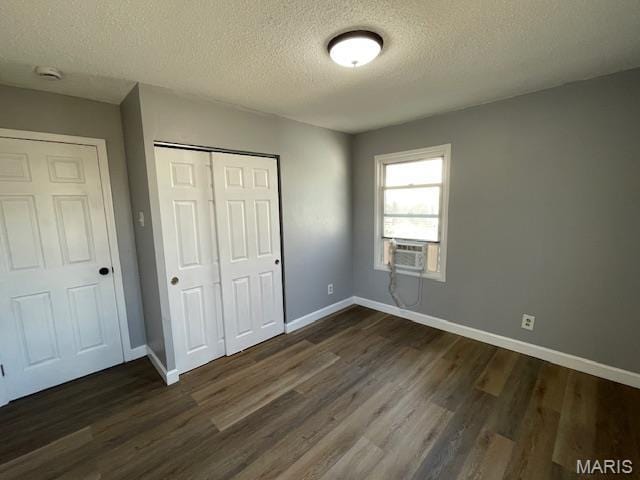 1339 Cabrillo Dr, Saint Louis, MO 63138 - unfurnished bedroom with a textured ceiling, a closet, dark wood-style flooring, baseboards, and cooling unit