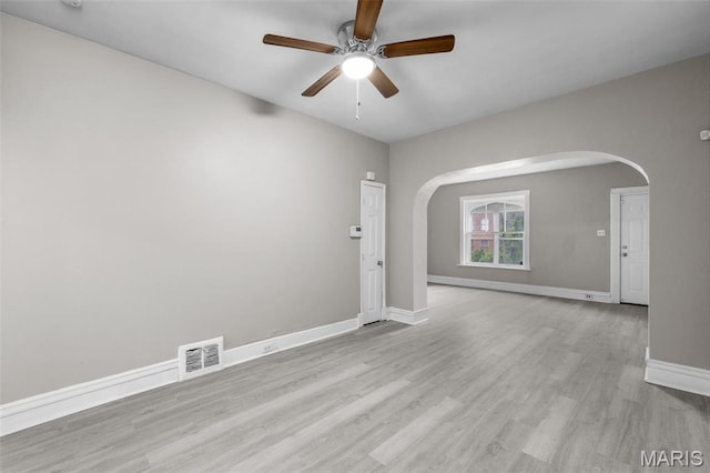 6040 Maple Ave, Saint Louis, MO 63112 - empty room featuring arched walkways, a ceiling fan, baseboards, and wood finished floors