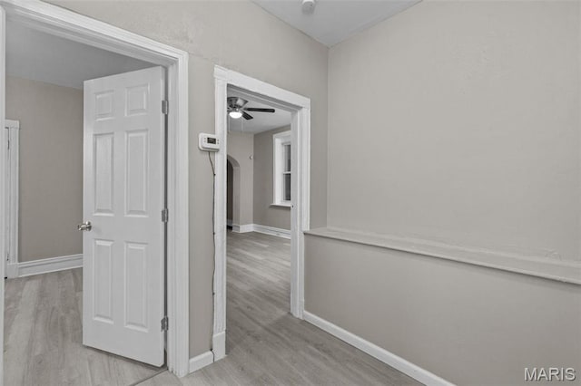6040 Maple Ave, Saint Louis, MO 63112 - hall featuring wood finished floors, baseboards, and arched walkways