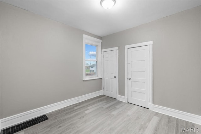 6040 Maple Ave, Saint Louis, MO 63112 - unfurnished bedroom featuring wood finished floors and baseboards