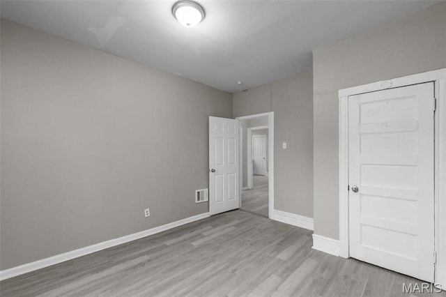 6040 Maple Ave, Saint Louis, MO 63112 - unfurnished bedroom with wood finished floors, baseboards, and a closet