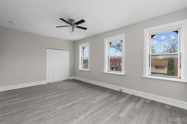 6040 Maple Ave, Saint Louis, MO 63112 - unfurnished bedroom with wood finished floors, baseboards, a closet, and ceiling fan