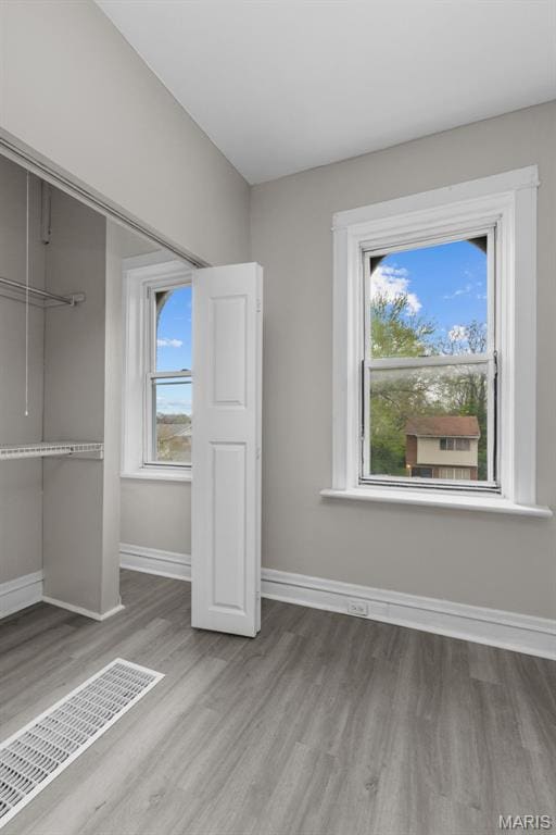 6040 Maple Ave, Saint Louis, MO 63112 - unfurnished bedroom with wood finished floors, baseboards, and a closet