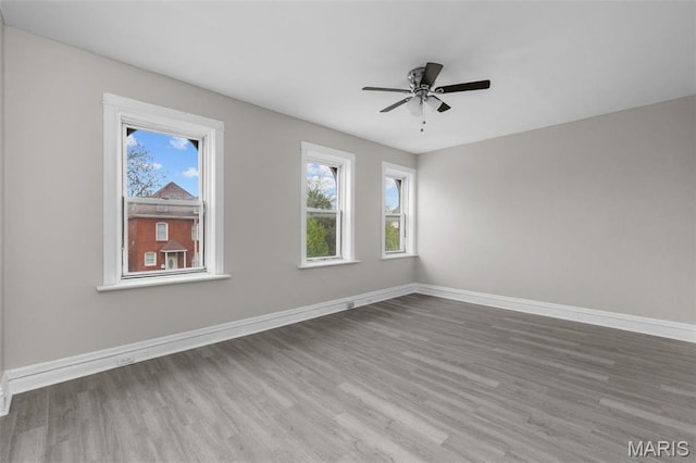6040 Maple Ave, Saint Louis, MO 63112 - spare room with wood finished floors, a ceiling fan, and baseboards