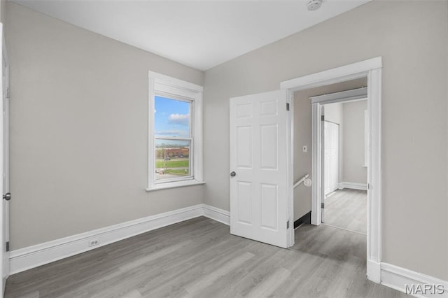6040 Maple Ave, Saint Louis, MO 63112 - unfurnished bedroom with wood finished floors and baseboards