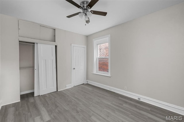 6040 Maple Ave, Saint Louis, MO 63112 - unfurnished bedroom with wood finished floors, baseboards, a closet, and ceiling fan