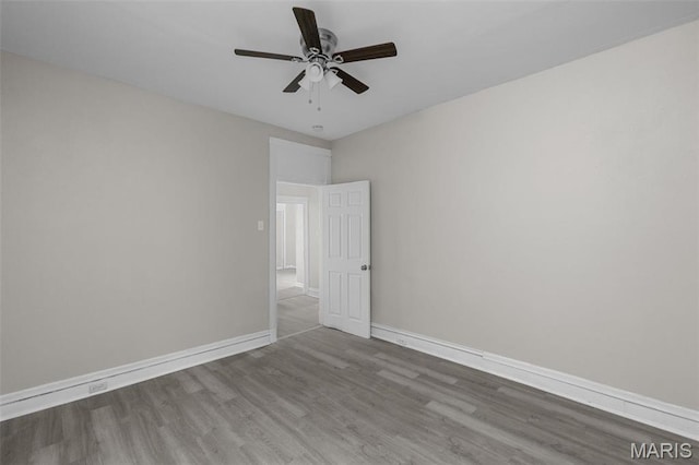 6040 Maple Ave, Saint Louis, MO 63112 - spare room with wood finished floors, a ceiling fan, and baseboards