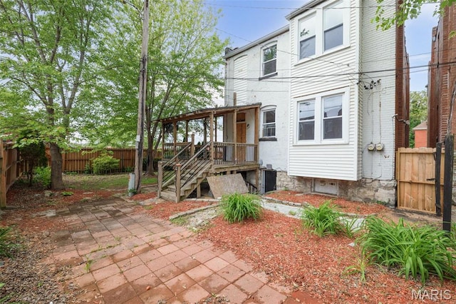 6040 Maple Ave, Saint Louis, MO 63112 - rear view of house with a fenced backyard and a patio area