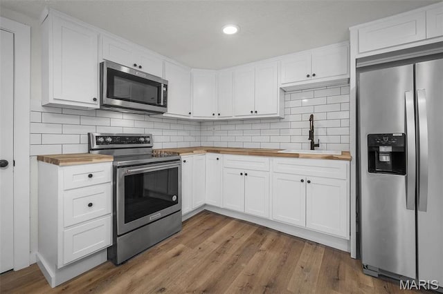 700 W Main St, Union, MO 63084 - kitchen featuring appliances with stainless steel finishes, butcher block counters, a sink, wood finished floors, and recessed lighting
