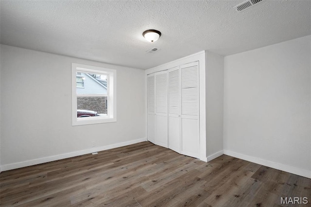 700 W Main St, Union, MO 63084 - unfurnished bedroom with wood finished floors, a closet, a textured ceiling, and baseboards
