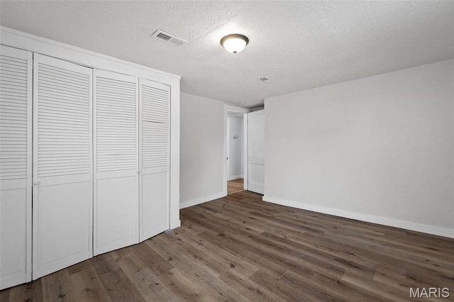 700 W Main St, Union, MO 63084 - unfurnished bedroom featuring wood finished floors, a closet, baseboards, and a textured ceiling