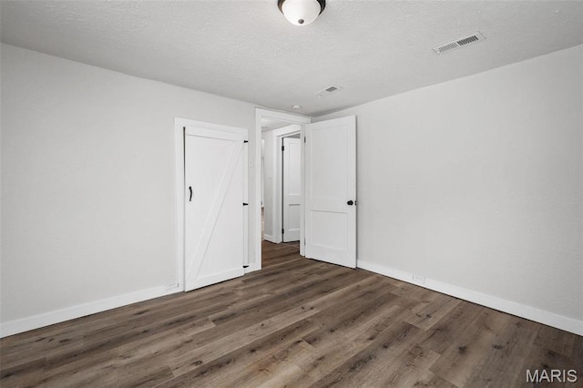 700 W Main St, Union, MO 63084 - unfurnished bedroom featuring wood finished floors, baseboards, and a textured ceiling