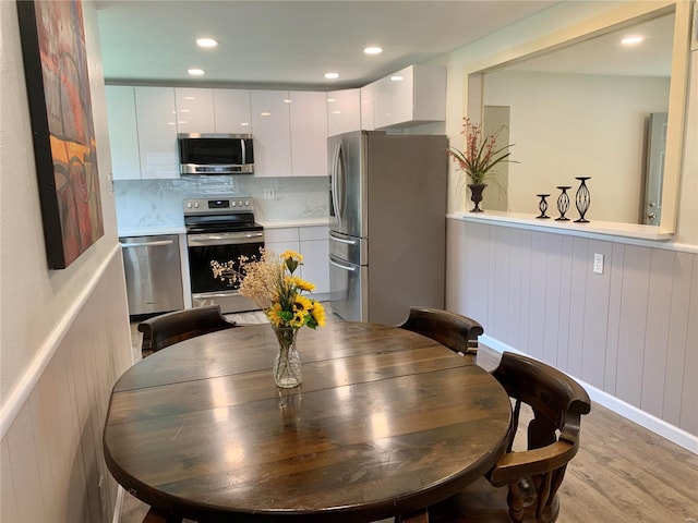 2903 Lesmer Ct, Overland, MO 63114 - dining area with light wood-style flooring, a wainscoted wall, and recessed lighting