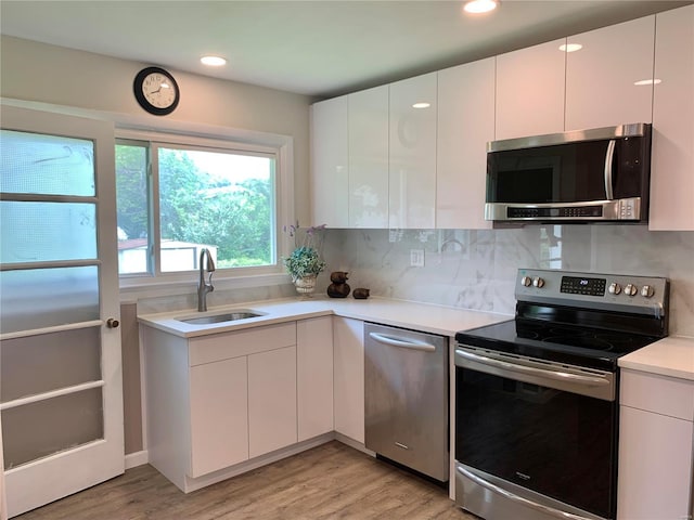 2903 Lesmer Ct, Overland, MO 63114 - kitchen with appliances with stainless steel finishes, modern cabinets, a sink, and recessed lighting