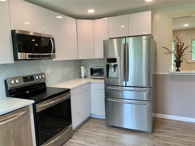 2903 Lesmer Ct, Overland, MO 63114 - kitchen featuring appliances with stainless steel finishes, light wood-style flooring, modern cabinets, a wainscoted wall, and recessed lighting