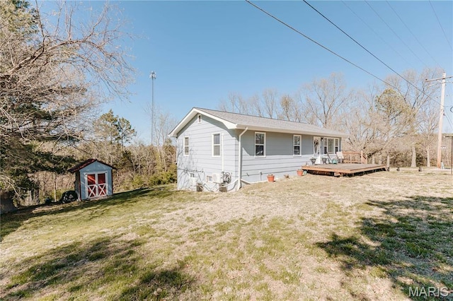 12561 Carroll Dr, Rolla, MO 65401 - back of house featuring a shed, a yard, a wooden deck, and an outbuilding