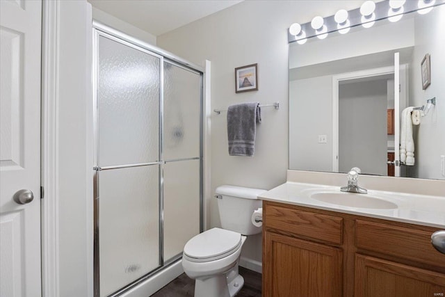 bathroom featuring a stall shower, toilet, and vanity