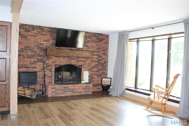 462 Il Route 127, Greenville, IL 62246 - unfurnished living room featuring a brick fireplace, wood finished floors, and baseboards