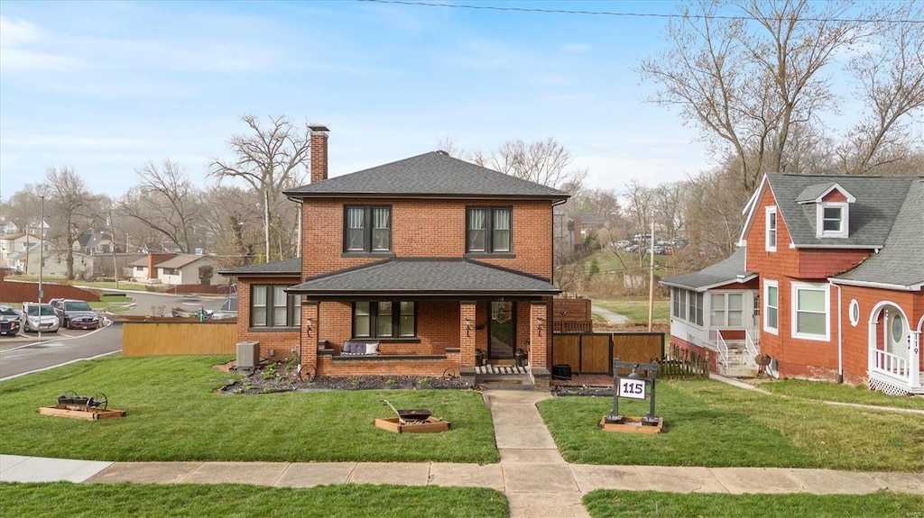 american foursquare style home featuring a porch, a chimney, brick siding, roof with shingles, and a residential view