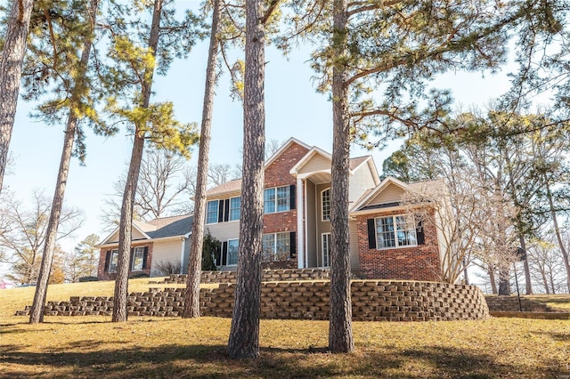 view of front facade featuring brick siding and a front lawn