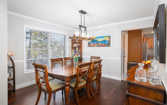 dining room featuring dark wood finished floors, a textured ceiling, ornamental molding, and baseboards
