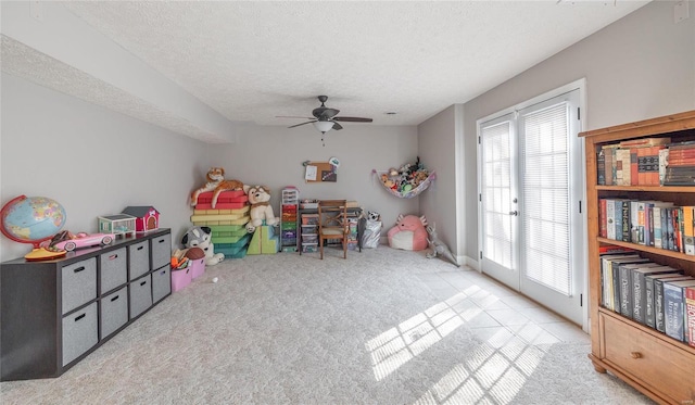 game room featuring carpet, a textured ceiling, and a ceiling fan