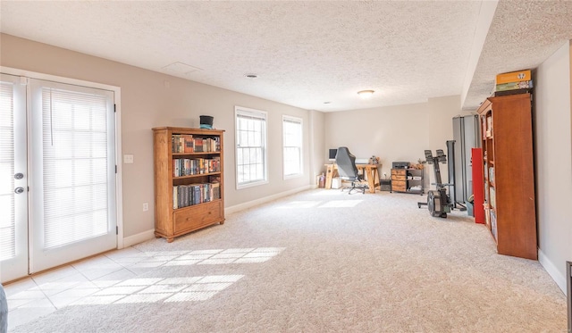 interior space with light carpet, a textured ceiling, and baseboards