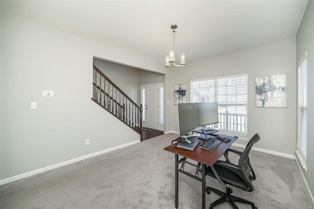 carpeted office space featuring a chandelier and baseboards