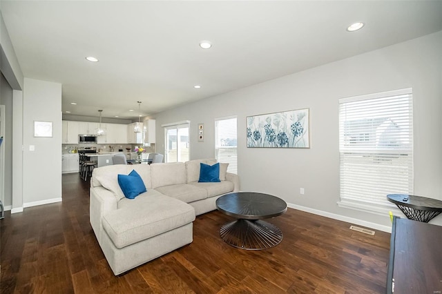 living area with recessed lighting, dark wood-style floors, and baseboards