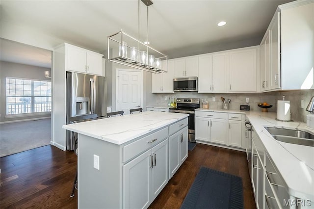 408 Sawgrass Ct, Saint Charles, MO 63301 - kitchen featuring appliances with stainless steel finishes, a sink, a kitchen island, dark wood-style floors, and recessed lighting