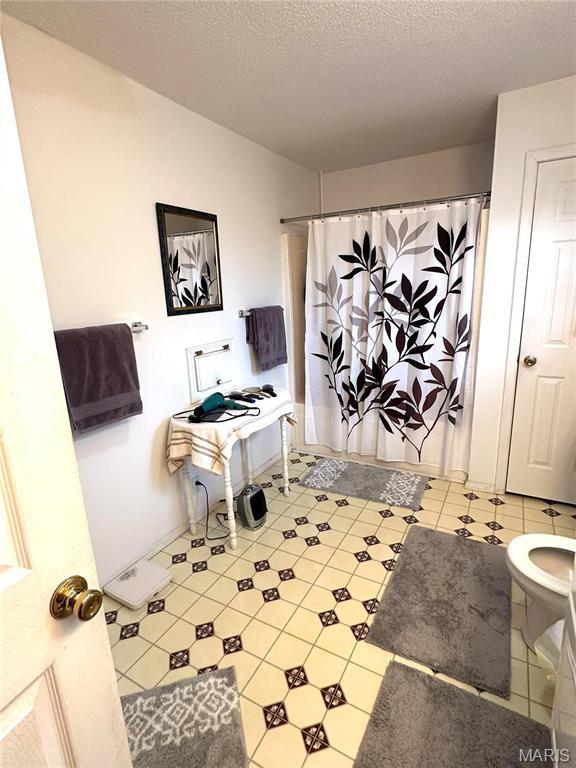 6474 State Highway H, Benton, MO 63736 - full bathroom featuring curtained shower, toilet, and a textured ceiling